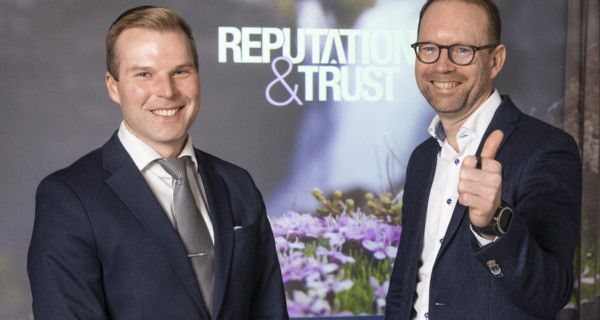 Ylävartalokuvat hymyilevistä Laurista ja Harrista puvut päällä. Harri näyttää peukkua.